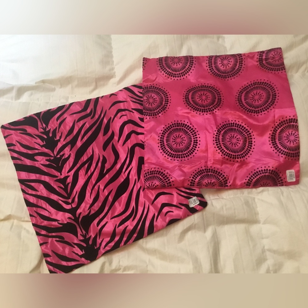 Two pink/patterned couch pillow cases.